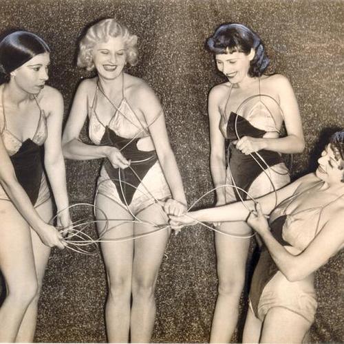 [Pauli Harrigan, Frances Jones, Toot Carlson and Florence Wallin play with section of Bay Bridge cable winding]