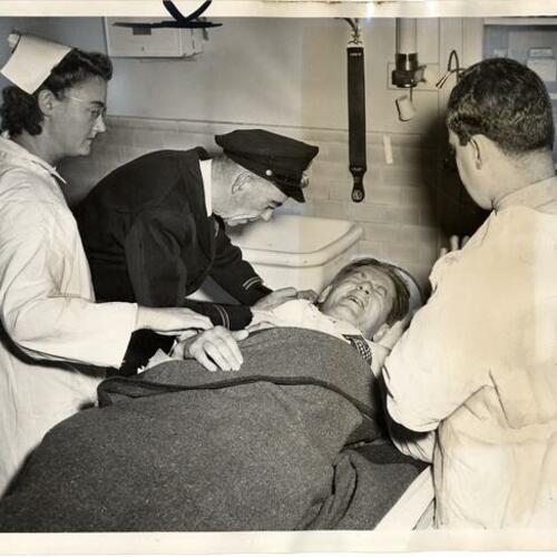 [Attorney George R. Andersen receiving first aid in Harbor Emergency Hospital]