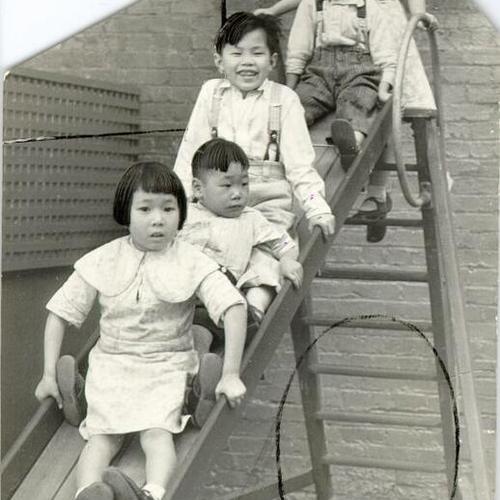 [Children playing on a slide]