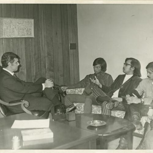 [George Moscone having a discussion in an office with Ed Lumin and Reverend A.C. Ubalde]