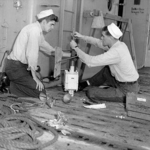 [Frank Thorton and Jimmy Strong working on wind direction intensity transmitter]