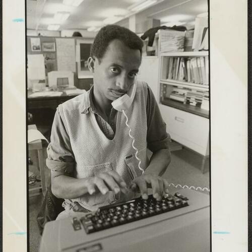 Tenderloin Times associate editor Stan West using typewriter and on phone call